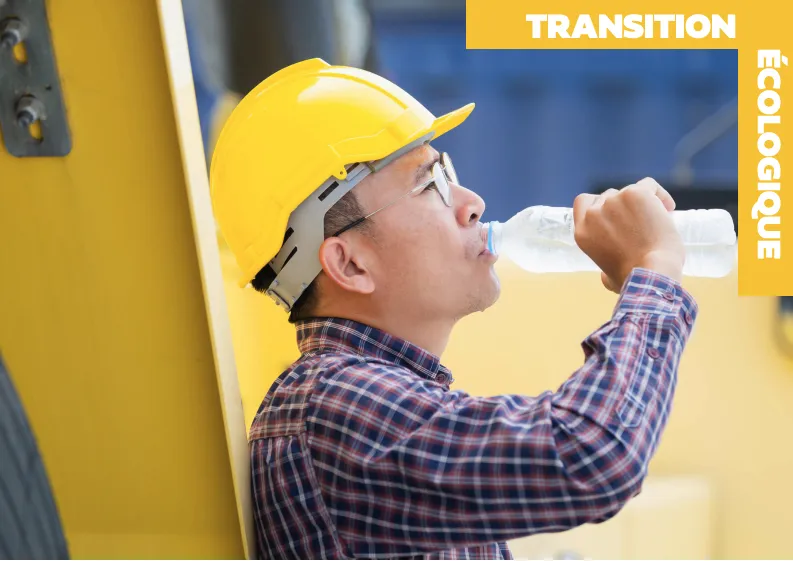 Un employé du bâtiment qui boit de l'eau